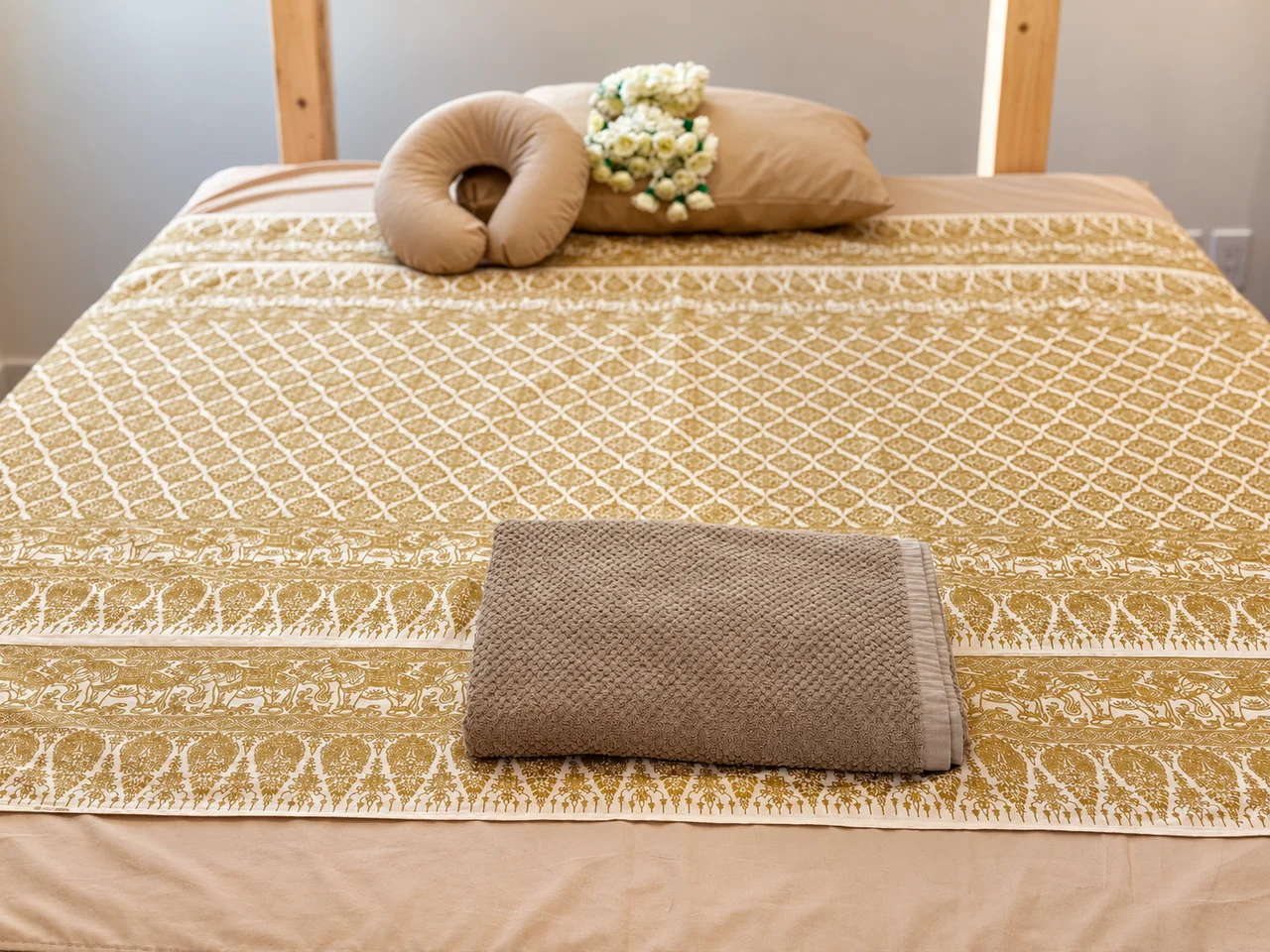 Thai treatment bed prepared with a folded towel and face pillow